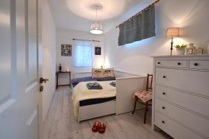 a small bedroom with a bed and a dresser at Gesztenyeház guest house with hot tub in Leányfalu