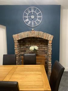 ein Esszimmer mit einem Tisch und einer Uhr an der Wand in der Unterkunft A&A Luxury Stay Tunstall in Sunderland