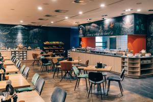 a restaurant with tables and chairs and a counter at Pentahotel Leipzig in Leipzig