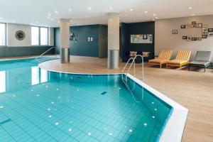 a large swimming pool in a hotel room at Pentahotel Leipzig in Leipzig