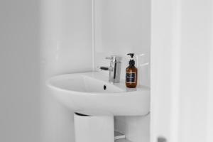 a bathroom sink with a bottle of alcohol on it at Sidlaw View in Dundee +32 photos