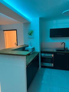a blue kitchen with a sink and a stove at Canopia Sunset in Mamoudzou +9 photos