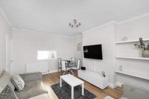 a white living room with a couch and a table at Sidlaw View in Dundee
