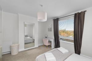 a bedroom with a bed and a desk and a window at Sidlaw View in Dundee