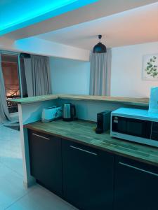a kitchen with a counter top with a microwave at Canopia Sunset in Mamoudzou
