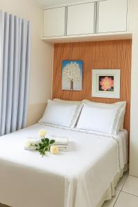 een slaapkamer met een wit bed met bloemen erop bij Cantinho da paz in Paranavaí