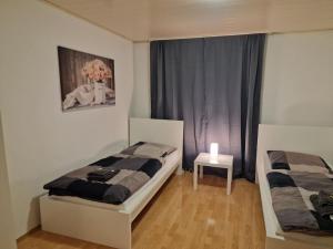 - une chambre avec 2 lits et une table ornée d'un vase de fleurs dans l'établissement 2-Zimmer Apartment in Gummersbach, à Fenke 5 autres photos