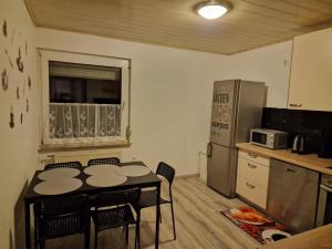 une cuisine avec une table, des chaises et un réfrigérateur dans l'établissement 2-Zimmer Apartment in Gummersbach, à Fenke
