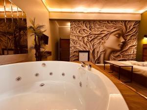 a bath tub in a bathroom with a painting of a woman at OTTO Boutique in Ankara +170 photos