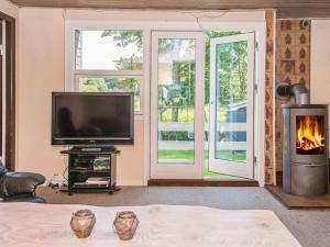 a living room with a television and a fireplace at 4 person holiday home in Haderslev in Haderslev