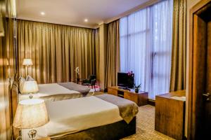 a hotel room with two beds and a television at Adisson Hotel Baku in Azadliq avenue in Baku +19 photos