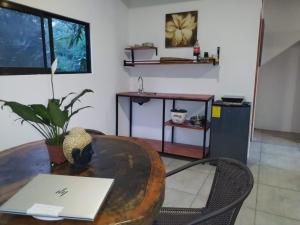 uma sala com uma mesa com um laptop em cima em El Tucan em Hone Creek