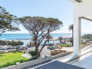 a view of the ocean from the balcony of a house at Blue Views Penthouse Beachfront Apartment with Pool in Cape Town