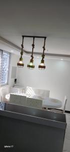 a kitchen with three lights and a table and chairs at Daisy Apptment in Malindi