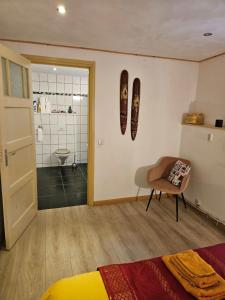 een slaapkamer met een bed en een stoel en een badkamer bij Hoeve de Haan in Bellingwolde