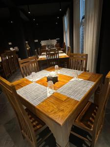 een houten tafel met daarop wijnglazen bij The Green Garniya Poolside and Mountain View Hotel in Belihul Oya