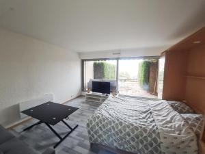 a bedroom with a bed and a flat screen tv at Au dessus des nuages Sublime Vue in Turckheim