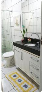 een badkamer met een wastafel, een toilet en een spiegel bij Cantinho da paz in Paranavaí