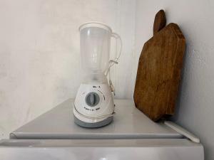 Ein Mixer steht mit einem Schneidebrett auf der Arbeitsfläche. in der Unterkunft Caminito Brasília Hostel in Luziânia