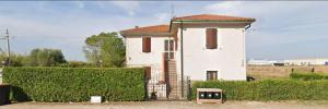 a white house with a gate in front of a hedge at Casa da Lilli in Cascina