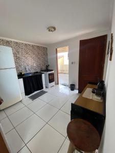 a kitchen with a refrigerator and a table and a chair at Desfrutando de Arraial Apartamento in Arraial do Cabo