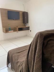 a bedroom with a bed and a flat screen tv at Desfrutando de Arraial Apartamento in Arraial do Cabo