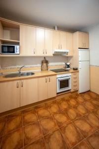 a kitchen with wooden cabinets and a white refrigerator at Chicote Rural in Mota del Cuervo