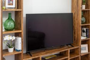 a flat screen tv on a wooden entertainment center at Chicote Rural in Mota del Cuervo