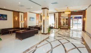 a lobby of a hotel with couches and tables at Adisson Hotel Baku in Azadliq avenue in Baku