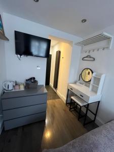 Un dormitorio con un escritorio y un televisor en la pared. en Double Guest Room 40 minutes from Central London, en Chessington 14 fotos más