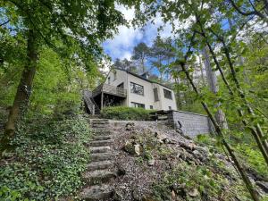 a house on a hill with stairs in the forest at Modern holiday home 5 rooms in Durbuy