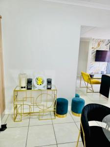 a living room with yellow and blue chairs and a table at The Blyde 104 in Pretoria