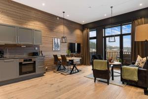 a kitchen and living room with a table and chairs at Trysil Alpine Lodge in Trysil