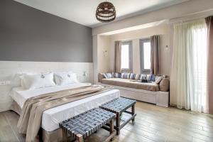 a bedroom with a large bed and a couch at Nissos Rooms Ammouliani in Ammouliani