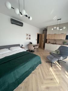 1 dormitorio con 1 cama verde y cocina en Horizon Park Lux II, en Boszkowo-Letnisko