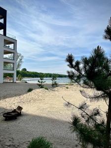 una playa con un pino en la arena en Horizon Park Lux II, en Boszkowo-Letnisko