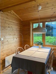 a dining room with a table and a lamp at Charming cabin by the sea in Lofoten in Sandsletta