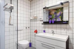 une salle de bain carrelée blanche avec toilettes et lavabo dans l'établissement Ferienwohnungen Im Löwengründle, à Unterkirnach 39 autres photos