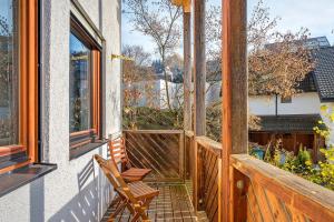 une terrasse couverte en bois avec une chaise sur un balcon dans l'établissement Ferienwohnungen Im Löwengründle, à Unterkirnach