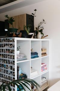 a white book shelf with potted plants and books at Bright and Modern Apt with an Industrial Touch in Pieta