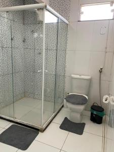 a bathroom with a glass shower and a toilet at Desfrutando de Arraial Apartamento in Arraial do Cabo