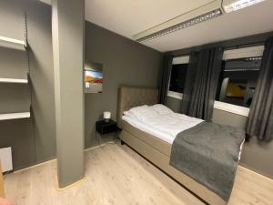 a small bedroom with a bed and a window at Ankenes Romutleie AS in Narvik