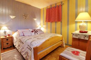 une chambre avec un lit et une table avec une lampe dans l'établissement Chalet exposition sud le Nid Douillet, à Gérardmer