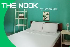 a bedroom with a bed with a green wall at The Nook by GreenPark in Puerto Princesa City