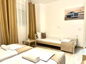 een kamer met drie bedden en een auto aan de muur bij LuxuryHomeUlcinj in Ulcinj