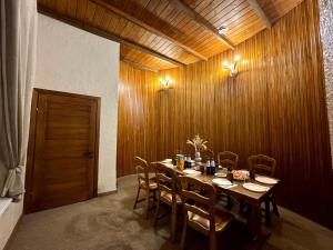 a wooden dining room with a table and chairs at Casa Cedru in Ialoveni +5 photos