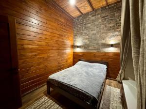 a small room with a bed in a wooden wall at Casa Cedru in Ialoveni