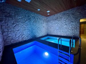 a bath tub with blue lighting in a room at Casa Cedru in Ialoveni