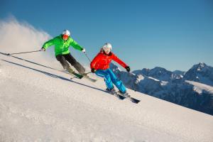 two people are skiing down a snow covered slope at Praschhof in Mariapfarr