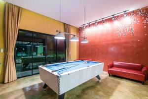 a room with a pool table and a red couch at Le Villa Huahin in Ban Khao Rang